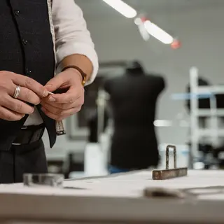 Schneider mit Maßband bei der Arbeit